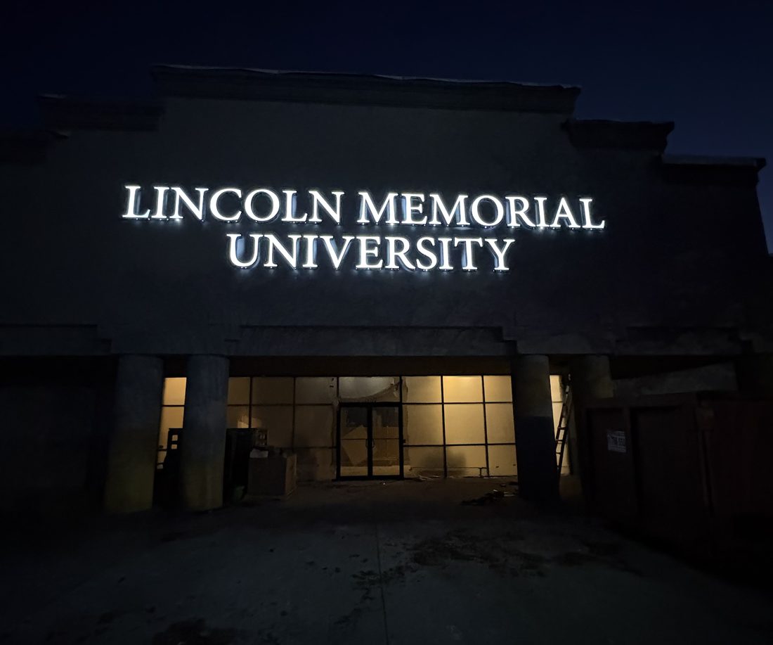 Illuminated channel-letter building sign at night