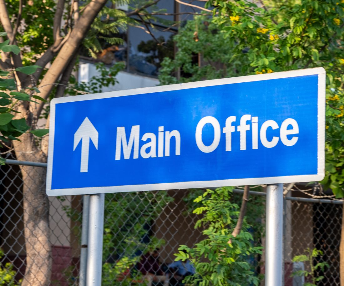 Directional wayfinding sign pointing to the main office